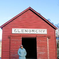 IMG_2553 Sharon in front of the iconic Glenorchy Red Shed, a historic landmark located on the waterfront reserve of Lake Wakatipu in Glenorchy, New Zealand. Originally...