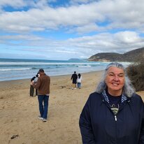 20250411_103403 Sharon on the beach at the Memorial Arch on the Great Ocean Road.