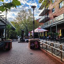 20250416_081249 A vibrant pedestrian area with outdoor dining and residential buildings at Ebenezer Pl and Liberman Cl
