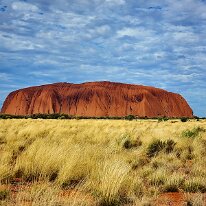 20250418_152147 This is Uluru (Ayers Rock) which is a large sandstone monolith that rises to an elevation of 348 m (1142 feet) and has a circumference of 9.4 km (5.8 miles).